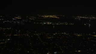 AX63_036 - 5K aerial stock footage pan across Mississippi River and Carrollton neighborhoods at night, New Orleans, Louisiana