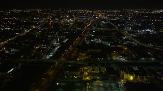 AX63_037E - 5K aerial stock footage approach Xavier University, pan to follow I-10 toward Superdome and downtown at night in Mid-City New Orleans, Louisiana