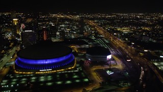 AX63_040 - 5K stock footage aerial video fly over the I-10 and Highway 90 interchange to approach Superdome in Downtown New Orleans, Louisiana at night