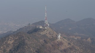 AX64_0015 - 5K aerial stock footage of emergency helicopter flying above the Hollywood Sign, Los Angeles, California