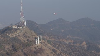 AX64_0016 - 5K aerial stock footage of emergency helicopter landing at Hollywood Sign, Los Angeles, California