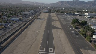 AX64_0043 - 5K stock footage aerial video of descending toward an airport runway at Whiteman Airport, Pacoima California