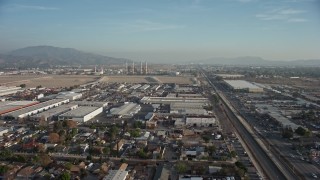 AX64_0044 - 5K aerial stock footage fly over homes and warehouses to approach power plant smoke stacks, Sun Valley and Pacoima, California