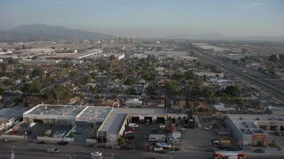 AX64_0048 - 5K aerial stock footage of fly over homes to approach warehouses and power plant in Pacoima and Sun Valley, California
