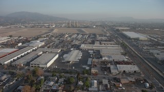 AX64_0049 - 5K aerial stock footage of warehouses near power plant with smoke stacks, Pacoima and Sun Valley, California