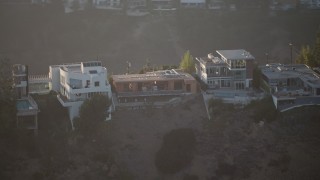AX64_0123 - 5K aerial stock footage of passing hilltop mansions in Hollywood Hills, California Sunset