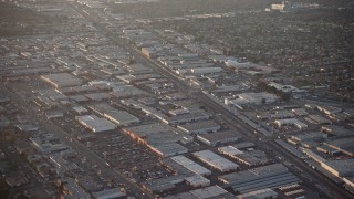 AX64_0133E - 5K aerial stock footage of warehouses and Sherman Way Square mall beside train tracks in North Hollywood, California, sunset