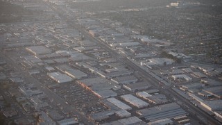 AX64_0134 - 5K aerial stock footage of warehouses and Sherman Way Square mall beside train tracks in North Hollywood, California, sunset