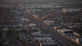 AX64_0140 - 5K aerial stock footage of San Fernando Road and warehouse buildings in Pacoima, California, Sunset