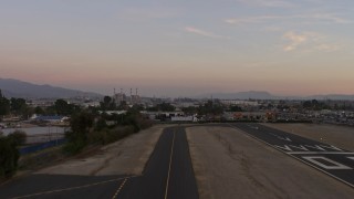 AX64_0142E - 5K aerial stock footage of lifting off from Whiteman Airport runway, Pacoima, California, Sunset