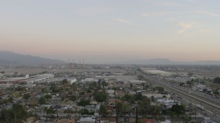 AX64_0143 - 5K aerial stock footage fly over warehouses to approach LADWP power plant in Pacoima, California, sunset