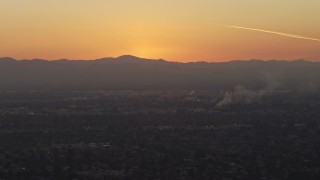 AX64_0144 - 5K aerial stock footage of suburban neighborhoods and mountains in Pacoima, California, sunset