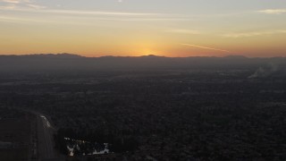 AX64_0145 - 5K aerial stock footage of suburban neighborhoods and distant mountains, Pacoima, California, sunset