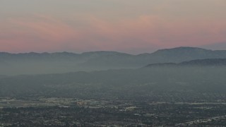 AX64_0159 - 5K aerial stock footage of San Gabriel Mountains from across the San Fernando Valley, Los Angeles, California, twilight