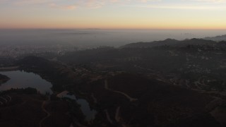 AX64_0163 - 5K aerial stock footage flyby hillside mansions in Hollywood Hills and reveal Hollywood Reservoir, California, twilight