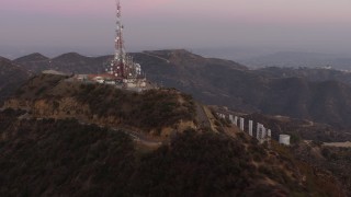 AX64_0164 - 5K aerial stock footage of radio tower above Hollywood Sign, Los Angeles, California, twilight