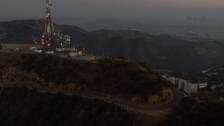 AX64_0164E - 5K aerial stock footage of radio tower above Hollywood Sign, Los Angeles, California, twilight