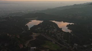 AX64_0168 - 5K stock footage aerial video of Hollywood Reservoir and Mulholland Dam in Los Angeles, California, twilight
