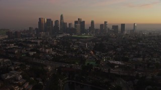 AX64_0184E - 5K aerial stock footage fly over Echo Lake and Highway 101 to approach Downtown Los Angeles skyline, California, twilight