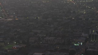 AX64_0198 - 5K aerial stock footage of a police helicopter flying over Downtown Los Angeles, California, twilight