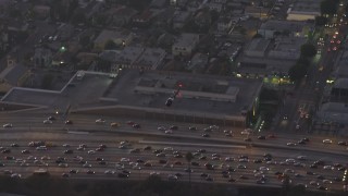 AX64_0199 - 5K aerial stock footage of a police helicopter flying over 110 freeway traffic in Downtown Los Angeles, California, twilight
