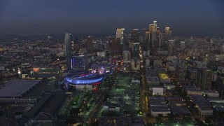 AX64_0219E - 5K aerial stock footage reverse view of Staples Center and The Ritz-Carlton, reveal skyscrapers in Downtown Los Angeles, California, twilight
