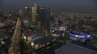 AX64_0223 - 5K stock footage aerial video of 110 Freeway, Staples Center arena, and Downtown Los Angeles skyscrapers, California, twilight