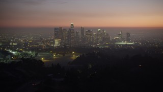 AX64_0258 - 5K stock footage aerial video fly over hill to reveal the Downtown Los Angeles skyline, California, twilight
