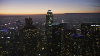 AX64_0267E - 5K aerial stock footage approach and fly over Downtown Los Angeles' tall skyscrapers, California at twilight
