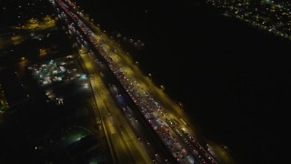 AX64_0318 - 5K aerial stock footage of heavy traffic on Interstate 405 in Westwood, Los Angeles, California, night