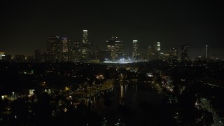 AX64_0353 - 5K aerial stock footage fly over Echo Lake to approach Downtown Los Angeles skyline at night, California