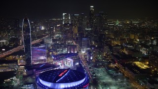 AX64_0363 - 5K stock footage aerial video fly over Staples Center toward Downtown Los Angeles skyscrapers, California, night