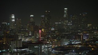 AX64_0388E - 5K aerial stock footage fly over Bendix Sign toward Downtown Los Angeles skyline, California, night