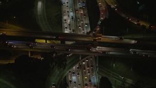 AX64_0397E - 5K aerial stock footage of Highway 110 and Highway 101 freeway interchange, Downtown Los Angeles, California, night