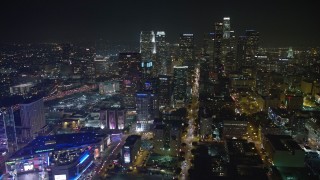 AX64_0407E - 5K aerial stock footage tilt from Staples Center arena to reveal skyscrapers in Downtown Los Angeles, California, night