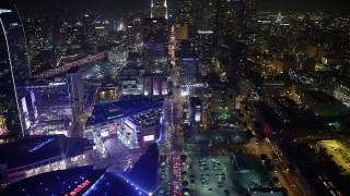 AX64_0408 - 5K stock footage aerial video tilt from Staples Center arena to reveal skyscrapers in Downtown Los Angeles, California, night