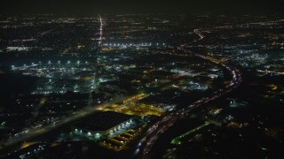 AX64_0437E - 5K aerial stock footage of Interstate 5 and San Fernando Road around warehouse building, Sun Valley, California, night