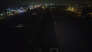 AX64_0445E - 5K aerial stock footage of approaching a runway at Whiteman Airport, Pacoima, California, night