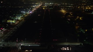 AX64_0446 - 5K aerial stock footage of approaching Whiteman Airport runway at night, Pacoima, California