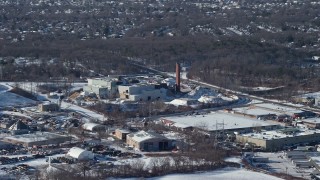 AX66_0004 - 4.8K aerial stock footage factory with smoke stacks in snow, Farmingdale, New York