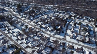 AX66_0007E - 4.8K aerial stock footage of a snow covered neighborhood in Plainview, New York