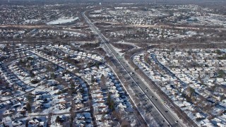 AX66_0011E - 4.8K aerial stock footage of freeway interchanges and neighborhoods in snow, Plainview, New York