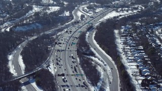 AX66_0015 - 4.8K aerial stock footage of an interstate by homes in snow, Jericho, New York