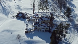 AX66_0017E - 4.8K aerial stock footage of a snow covered mansion, Jericho, New York