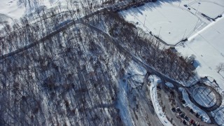 AX66_0019 - 4.8K aerial stock footage of bare forest in snow, Old Westbury, New York
