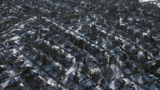 AX66_0025 - 4.8K aerial stock footage an orbit of a snow covered suburban neighborhood, East Hills, New York