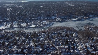 AX66_0031E - 4.8K aerial stock footage fly over home toward ice-covered Manhasset Bay in New York