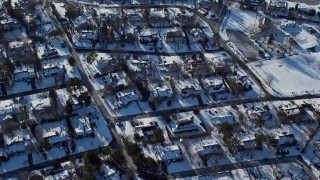 AX66_0036E - 4.8K aerial stock footage of a bird's eye view of residential neighborhood and waterfront homes in snow, Saddle Rock, New York