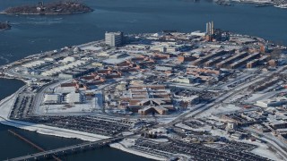 AX66_0049 - 4.8K aerial stock footage of prison buildings on Rikers Island in snow, New York