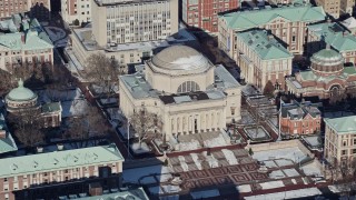 AX66_0072E - 4.8K aerial stock footage orbit Columbia University's Low Memorial Library with snow, New York City